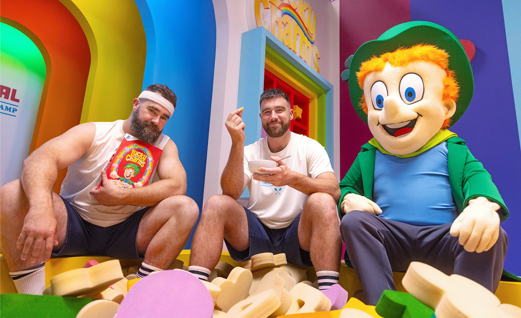 Jason and Travis Kelce sitting with the Lucky Charms leprechaun.